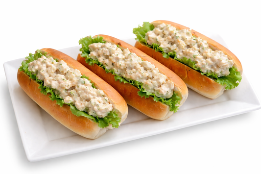 Cocktail subs with creamy filling and green lettuce on a rectangular platter
