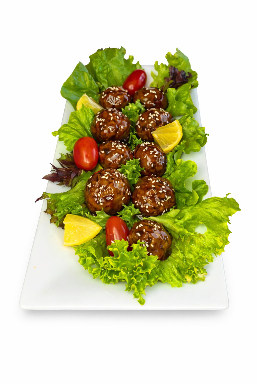 Beef frikkadal meatballs on lettuce with lemon wedges and cherry tomatoes