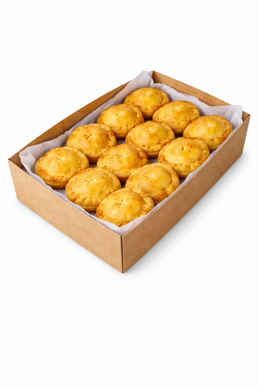 Baked pies in cardboard box with golden pastry tops